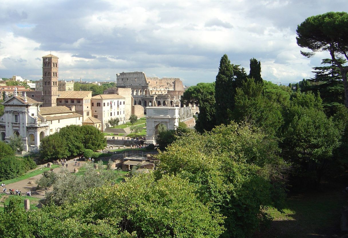 Elevated view over Roman Forum greenery, the Arch of Titus and Santa Francesca Romana bell tower toward the Colosseum