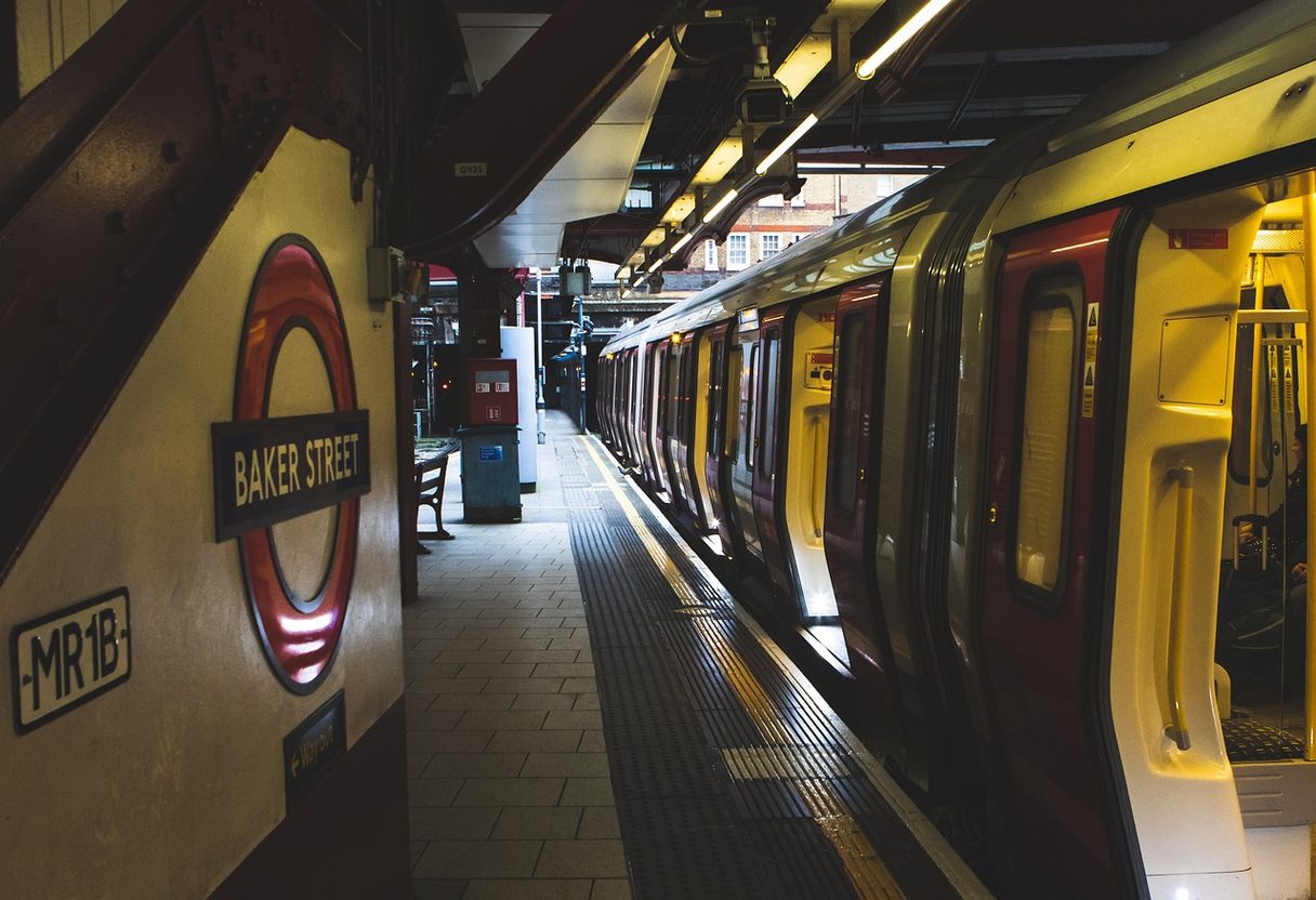 London Underground train with open doors at Baker Street platform beside the red roundel sign
